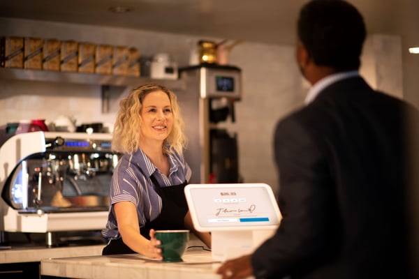 Cliente firmando en una tableta en una cafetería