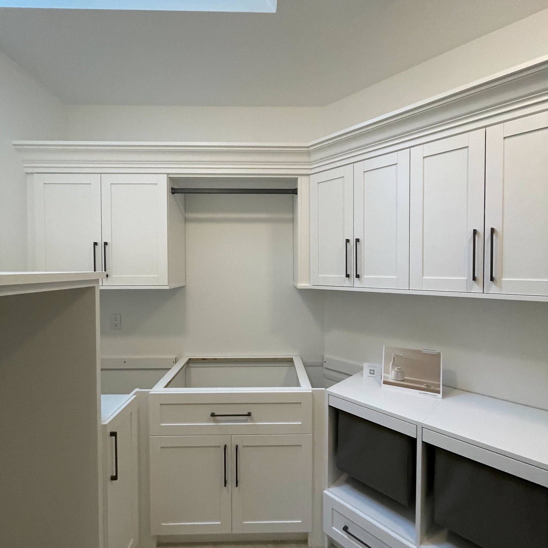 Custom laundry room with white cabinets