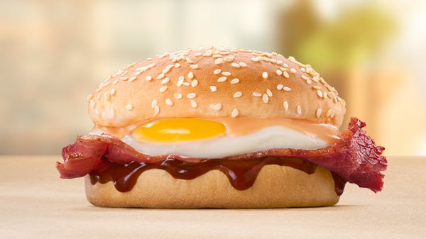 The Macon & Egg Bun on a brown surface with a blurred background.