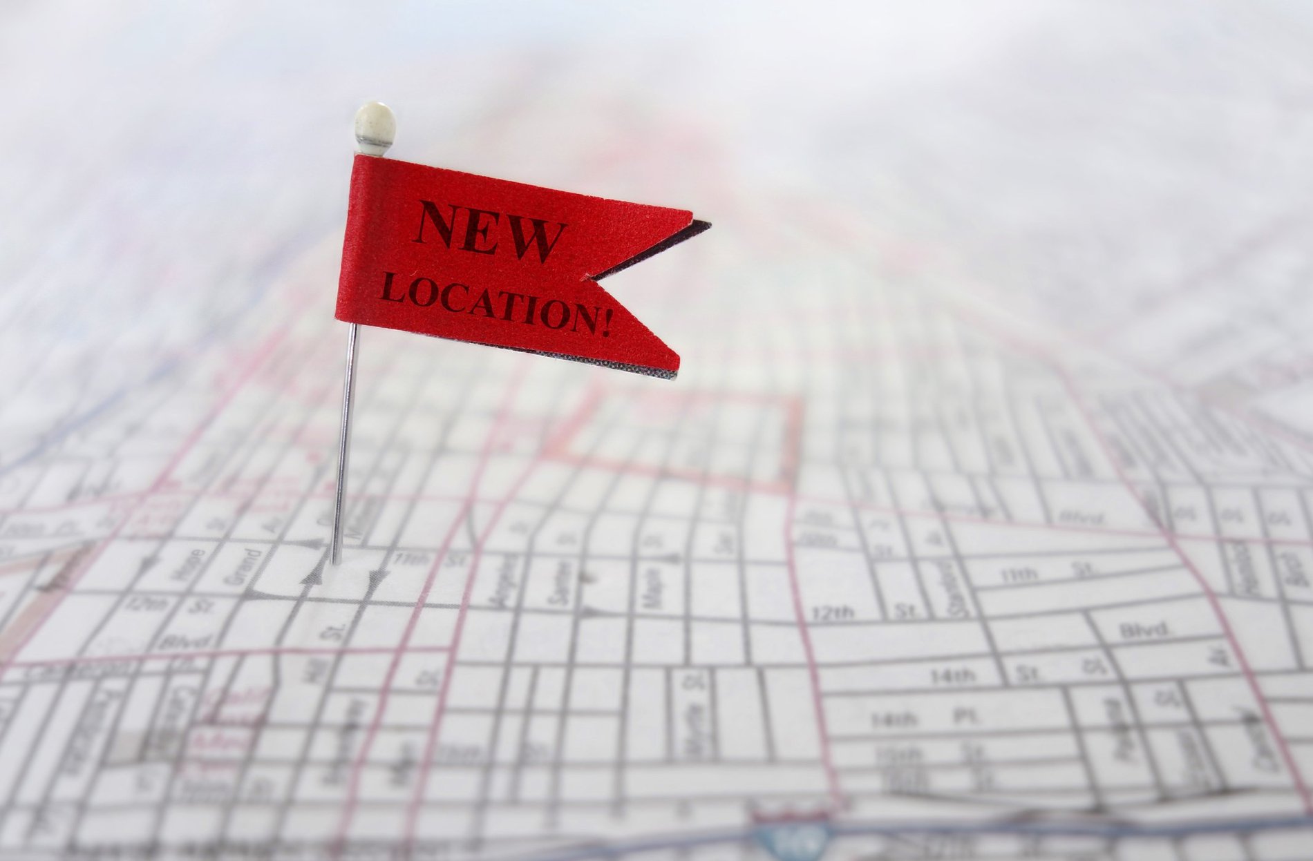 Pin in map with red flag that says New Location