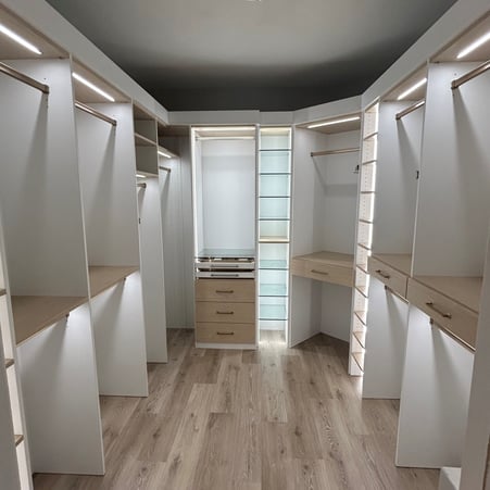 Walk-in closet in Washed White finish with Natural shelves and Natural drawers fronts. Includes Everstyle jewelry drawers, glass shelves, and integrated lighting inside of partitions and top shelves.