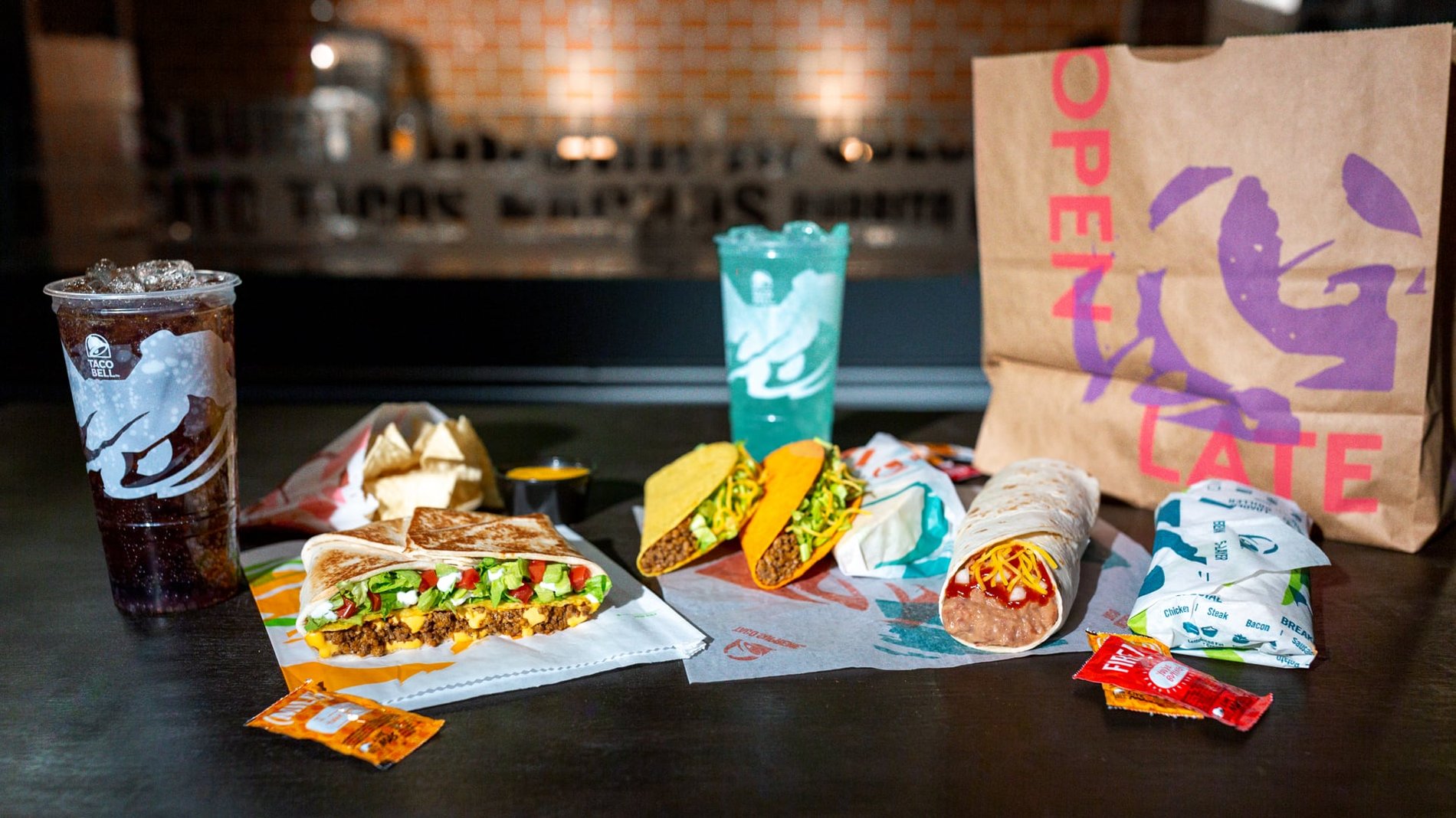 An arrangement of a Taco Bell Order including 1 Crunchy Taco, 1 Doritos® Loco Taco, 1 burrito, a couple of wrapped soft tacos, & 1 Crunchwrap Supreme®.