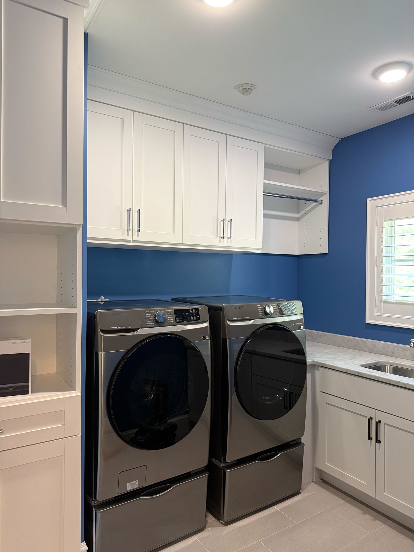 White laundry room cabinets with hanging space