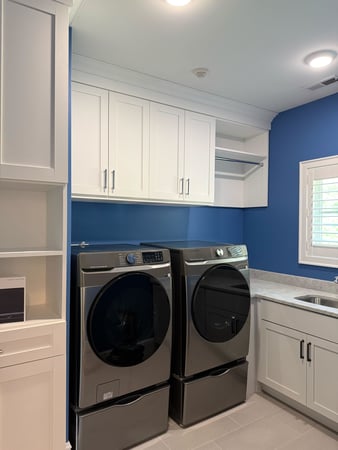 White laundry room cabinets with hanging space
