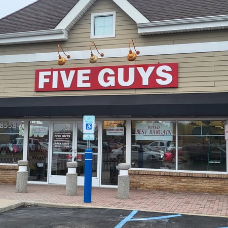 Exterior photograph of the Five Guys restaurant at 855 Montauk Highway in Shirley, New York.