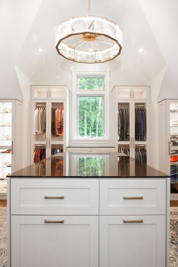 Attic converted to dressing room with custom island, glass doors, and shelves in Blue Bell, Pennsylvania by California Closets of Philadelphia and Delaware