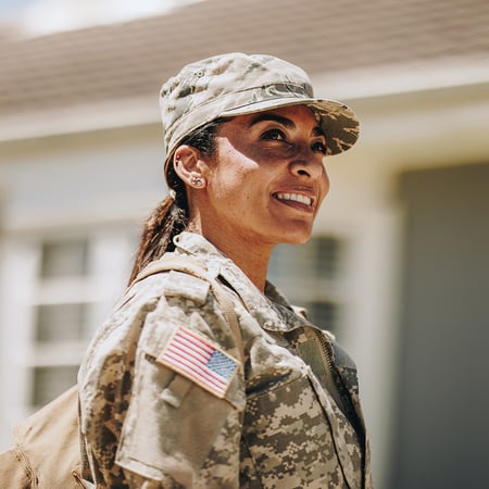 A woman in military camo looking to her right.