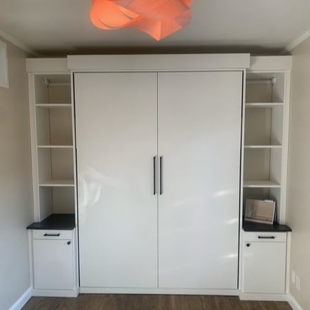 Guest room storage in Dove finish with Milano Grey countertops, matte black traditional round hardware, and custom wall bed.