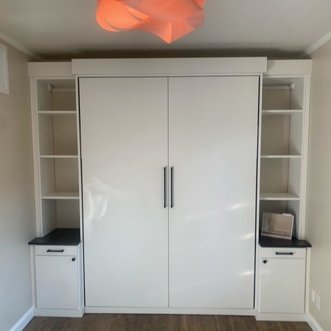 Guest room storage in Dove finish with Milano Grey countertops, matte black traditional round hardware, and custom wall bed.