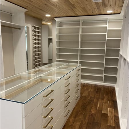 White custom closet organization with shoe organization and gold hardware by California Closets Baldwin County & Mobile, Alabama.