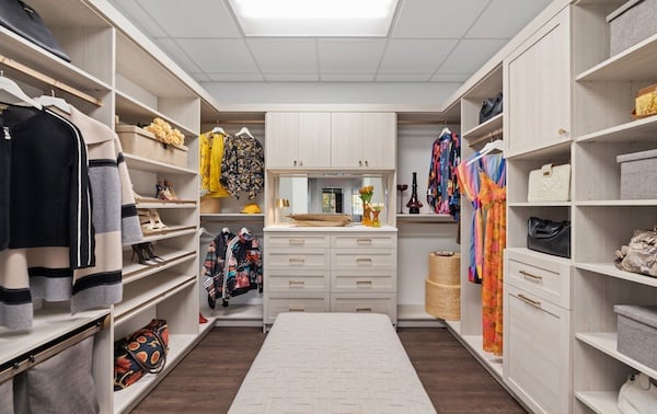 Walk in closet design at California Closets Wixom showroom featuring custom closets, closet organizers, cabinets, drawers, and shelving