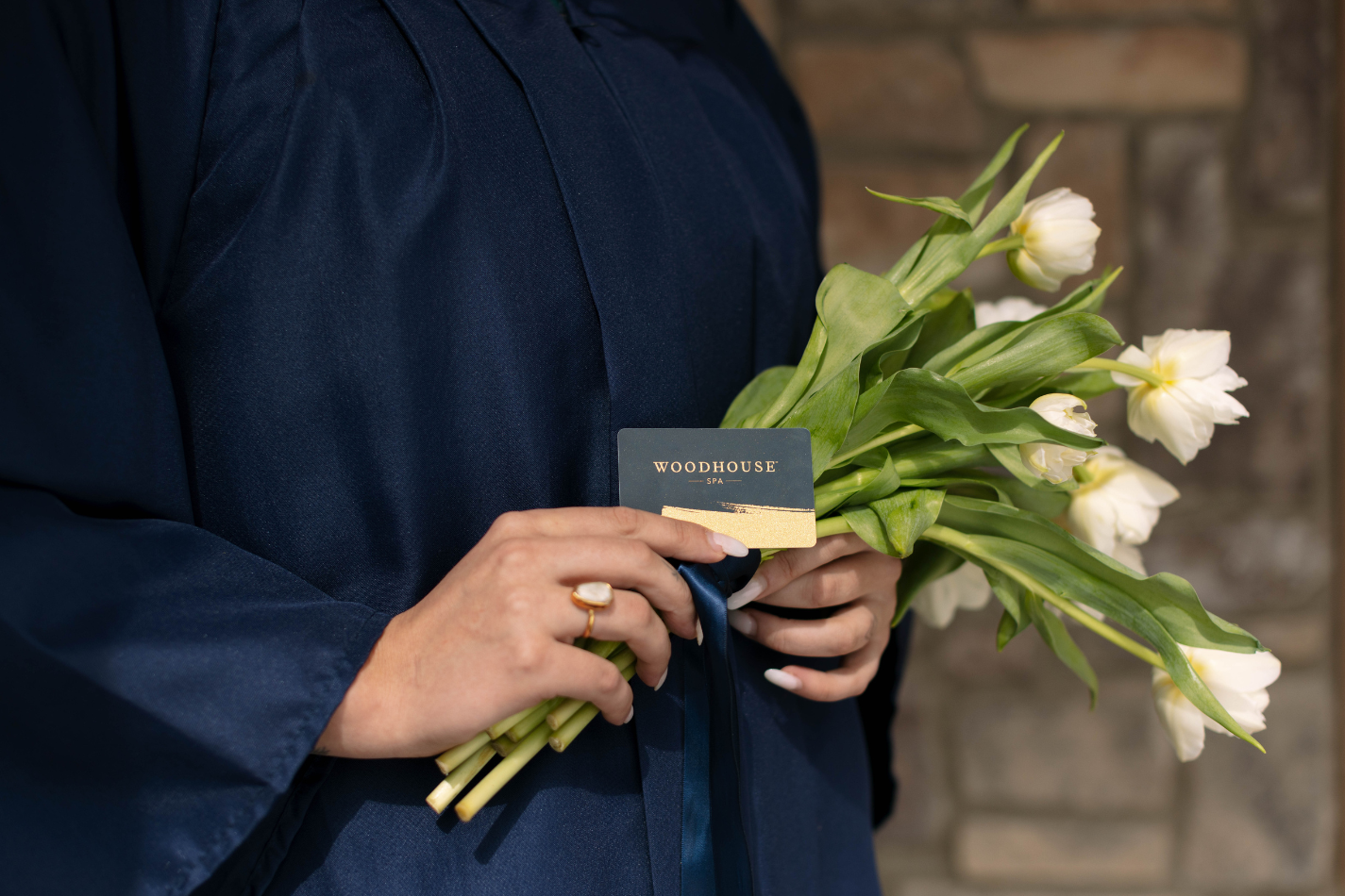 graduate holding a gift card and flowers