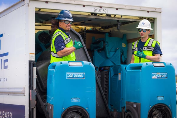 First Onsite Dayton team members load dehumidifiers into truck for water damage restoration.