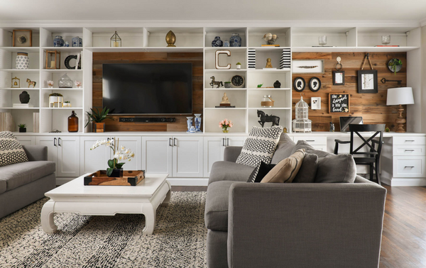 Traditional white living room with entertainment center and custom built workspace with bookshelving to display collectibles with closed cabinetry on bottom to conceal wires Katonah New York Westchester County