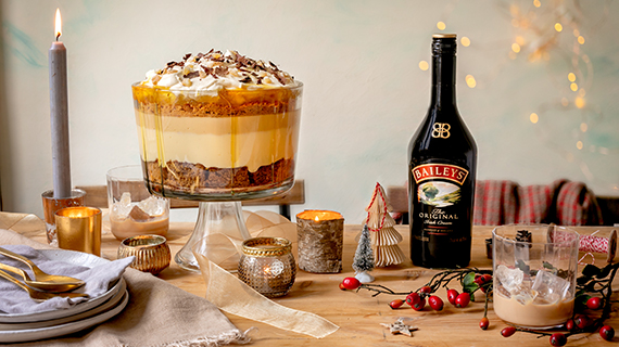 Table decorated with Christmas ornaments and a Baileys-infused gingerbread trifle