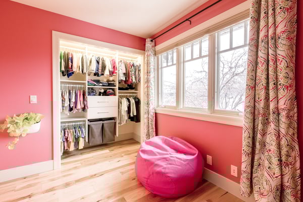 Kid's closet with hanging space, drawer storage, and pull-out hampers by California Closets Edmonton, Alberta.