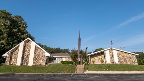 The Church of Jesus Christ of Latter-day Saints meetinghouse in Flintstone, Georgia (Chattanooga Valley congregation). The meetinghouse sits on top of a hill. It is made entirely of stone. Three ornamental metal spires are situated in front of the meetinghouse, to the left of the American Flag pole. The name "The Church of Jesus Christ of Latter-day Saints" is mounted directly on the meetinghouse's stone.