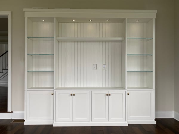 White media center with lower cabinets and shiplap backing
