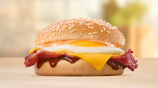 The Macon, Egg & Cheese Bun on a brown surface with a blurred background.