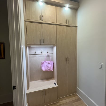 This mudroom is in the Natural finish with gold hardware and overhung top cap with puck lights.
