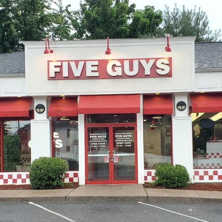Exterior photograph of the entrance to the Five Guys restaurant at 168 Elm Street in Enfield, Connecticut.