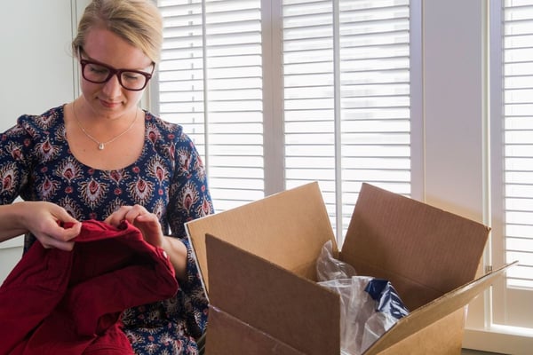 A person looking at a red shirt and preparing a return