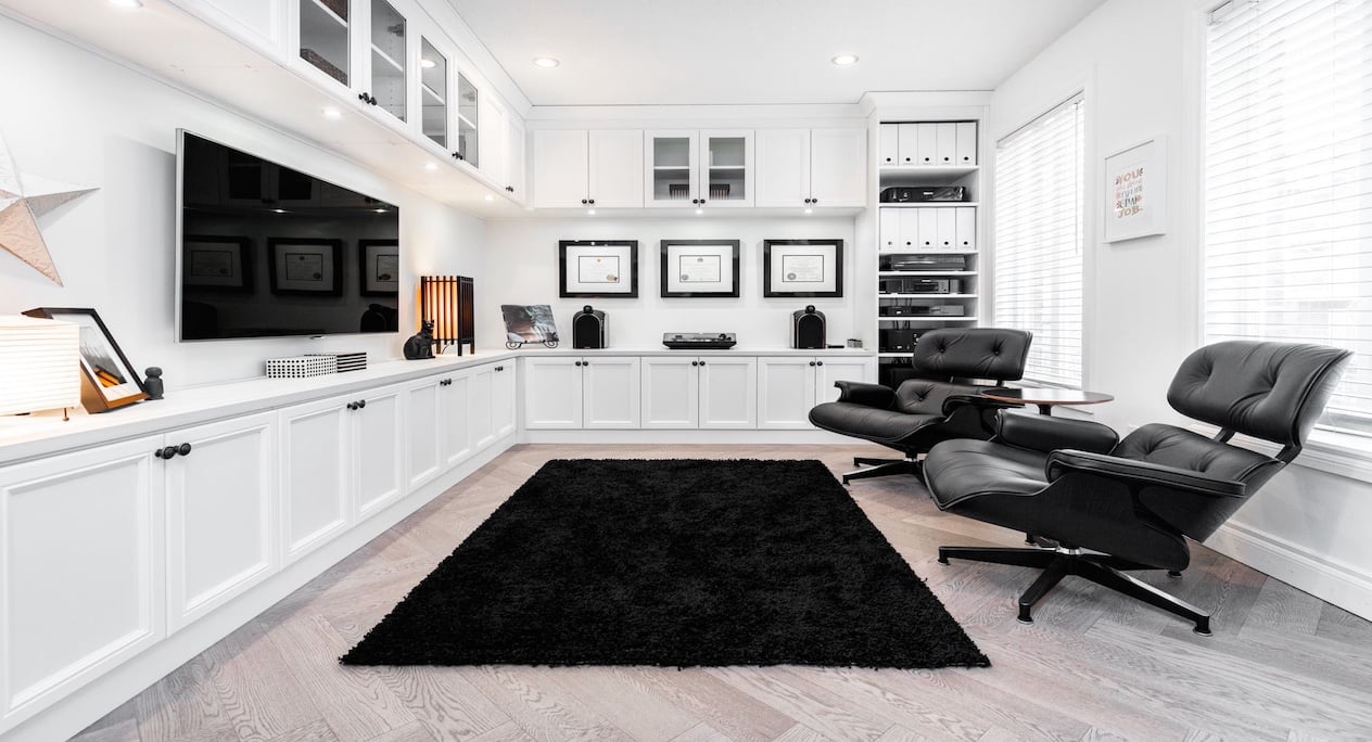 custom home office with white cabinet and desk chairs and a tv