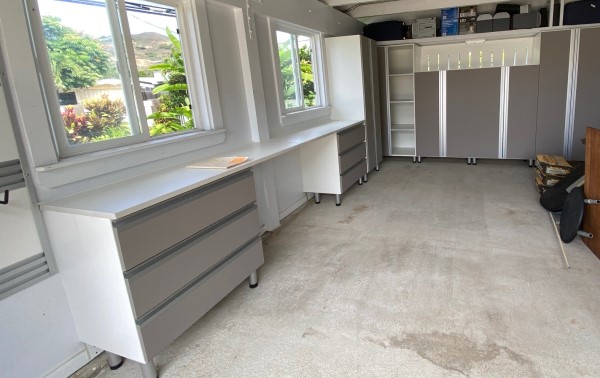 Luxe garage with white storage cabinets, extruded handles and light brown drawer and cabinet faces.