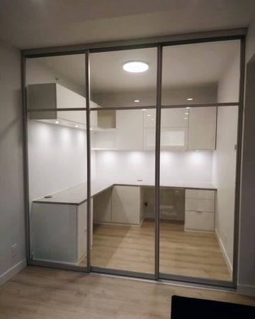 Custom built office tucked behind a three panel glass sliding door