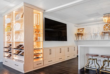 Commercial showroom designed with custom shelving, cabinets and drawers in natural finish by California Closets