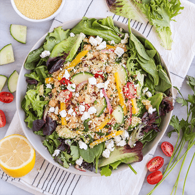 couscous greek salad with spring greens and feta