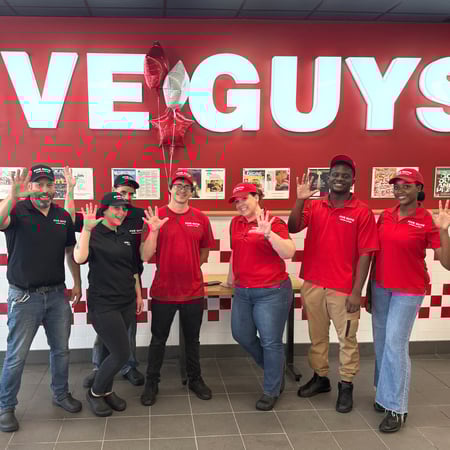 Store employees pose for a photograph ahead of the reopening of the Five Guys restaurant at 15 Webb Place in Dover, New Hampshire.