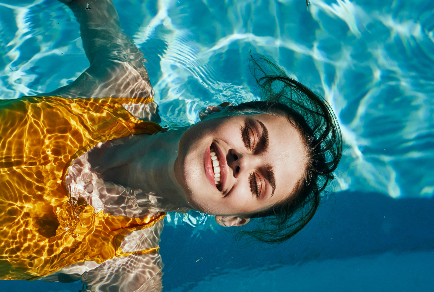 Women smiling and floating in a swimming pool, immersed in the blissful aftermath of a rejuvenating Woodhouse spa experienc