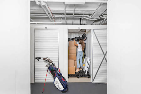 Woman packs her storage unit with baby stroller, golf clubs, boxes and more