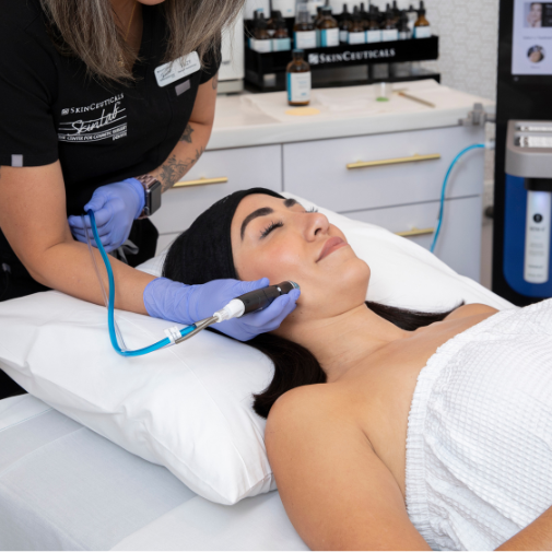 Patient receiving SkinBright treatment featuring Hydrafacial tool.