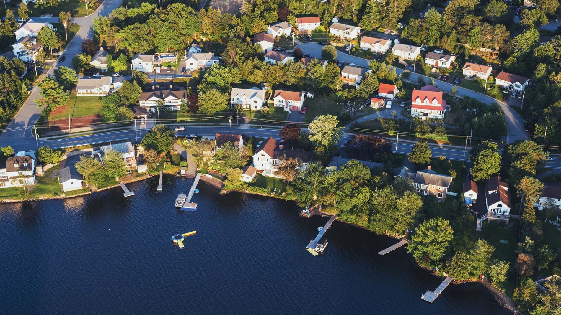 A daytime aerial view of homes lining the shoreline of Lake Micmac in Dartmouth, Nova Scotia.