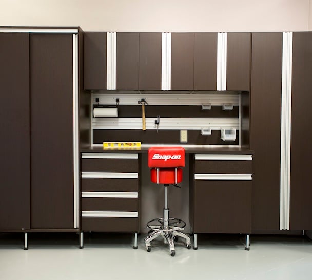 custom garage workspace storage with slat wall and cabinets