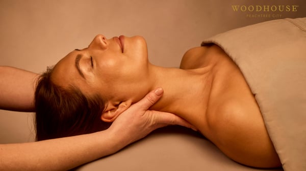 Woman enjoying a hot stone massage and Hydrafacial at Woodhouse Peachtree City