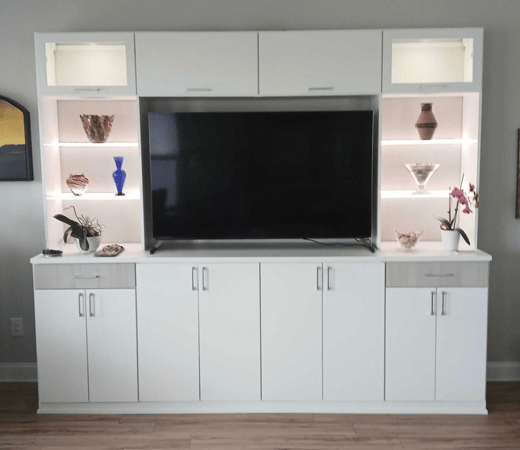 White cabinets and lit shelving for a living room or bedroom wall.