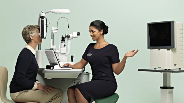 A Specsavers' eye doctor conducting a routine examination of a patient.