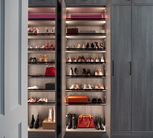 Walk-in dark gray closet with angled fenced shoe shelving floor to ceiling, behind closed cabinetry with modern black hardware Dutchess County NY