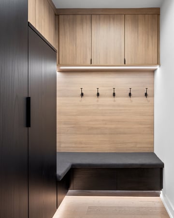 Two Tone Mudroom with brown and black tones, hooks and a bench by California Closets Northern Michigan