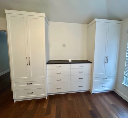 Custom bedroom wardrobe system with white built-in cabinets, drawer storage, and modern closet organization solutions creating clean, functional home storage in Rochester Hills, Michigan