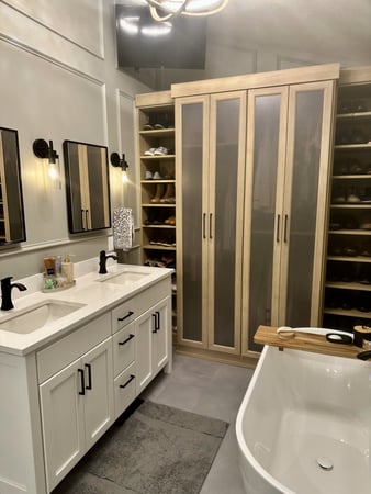Custom bathroom storage which includes glass doors and tons of shelving for shoe storage. Each Shelf has fixed lighting to make finding your shoes easier.