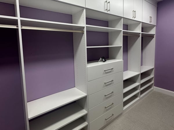 Greensboro - Custom closets - purple walk-in closet with white shelving, clothing racks, drawers, and cabinets along the top