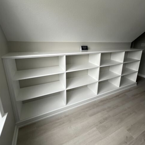 Virginia Beach - Custom closets - Custom built-in shelving under a sloped ceiling in a neutral room.