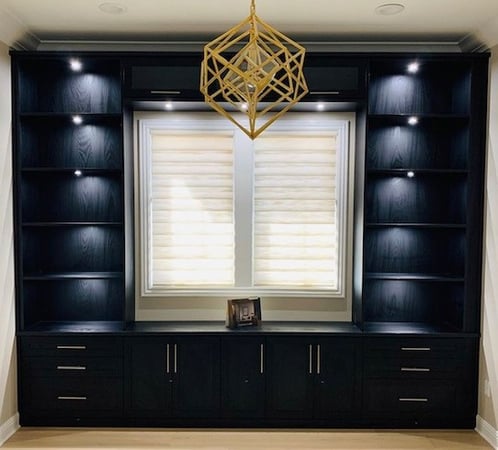 Large entertainment center in dark finish with recessed lighting and open shelving.