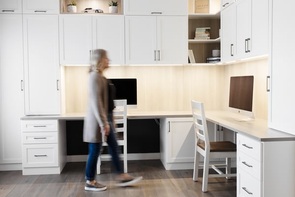 Home office in a white finish with contrasting counter top, backing, and display boxes. Combination of closed and open cabinetry for storage and display.