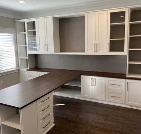 white and brown home office with large desk and cabinets