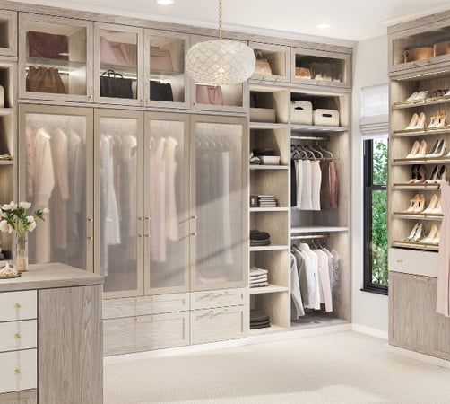 Custom Walk-In Closet Floor-to-Ceiling Cabinetry Glass Front Doors Hanging Sections Open Shelving Drawer Storage Shoe Storage Light Wood Finish by California Closets South Palm Beach Florida